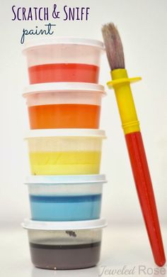 a stack of plastic containers with paint and a brush