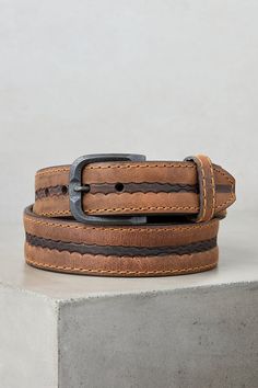 Made from genuine American bison leather, the durable Big Timber belt accents your outfit with rich detailing, from its burnished center coloring over a subtle tooled pattern to its distressed metal buckle with a patina finish. Contrast stitching throughout lends visual appeal, while flat, hand-painted edges and a blunt tapered tip that slides through a single leather keeper finish this handsome design. Lined with full-grain leather. Rustic Leather Belt With Antique Buckle, Artisan Leather Belt Buckle With Antique Design, Rugged Distressed Brown Belt With Antique Buckle, Rustic Brown Hand-tooled Belt, Rustic Brown Hand Tooled Belt, Rustic Distressed Brown Belt With Antique Buckle, Rugged Distressed Brown Belt Buckle With Antique Finish, Rugged Distressed Brown Belt Buckle With Antique Buckle, Distressed Brown Rugged Belt Buckle With Antique Finish