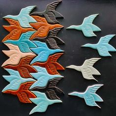 several different colored birds on a black surface