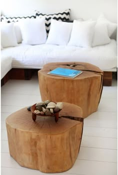 two wooden stools made out of logs with rocks in the middle and a book on top