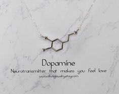 "Silver Dopamine Molecule Necklace. I use the most gorgeous high-quality sparkly sterling silver chain which makes this necklace as one reviewer says \"absolutely stunning.\" Keep this in mind when comparing similar products. Dopamine is a modern symbol of love and desire. Dopamine molecules interact with receptors in the brain to induce feelings of love, attention, and excitement. Dopamine also has an elegant shape. As a necklace, it is an attention-grabber. Perfect for the chemistry or biology Chemistry Necklace, Dopamine Molecule, Biology Jewelry, Molecule Necklace, Attention Grabber, Feelings Of Love, Diy Jewelry Ideas, Necklace Extender, Biochemistry