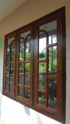 an open window on the side of a building with wooden frames and glass panes