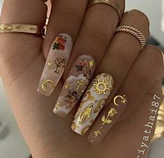 a woman's hand with some gold and white nail polishes on her nails