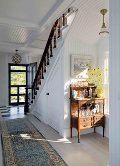 an entry way with stairs and a rug on the floor