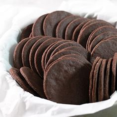 a white bowl filled with chocolate cookies on top of a table