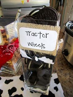 a glass vase filled with cookies on top of a table next to a sign that says tractor wheels