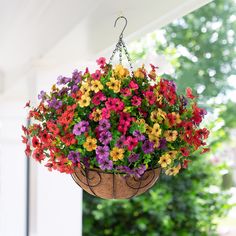 a hanging basket filled with colorful flowers on a porch