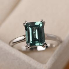 This ring features a 7*9mm emerald cut lab green sapphire and sterling silver finished with rhodium. Customization is available. It is made by hand, and it will take about 7 days to finish the ring after your payment is completed.  It include the lab emerald ring and the band. Main stone: lab green sapphire Main stone weight: Approx 2.60 ct Metal type: sterling silver finished with rhodium/14k white gold/14k rose gold/14k yellow gold Accent stone: none Customization is available, I also can make Emerald Silver Jewelry, Emerald Green Engagement Ring Silver, Silver Green Ring, Emerald Engagement Ring Silver, Emerald Cut Sapphire Ring, Emerald Cut Solitaire Ring, Topaz Rings, Vowel Renewal