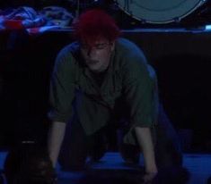 a man with red hair is kneeling down