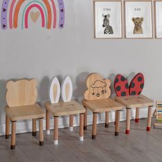 children's wooden chairs in front of a wall with pictures on it