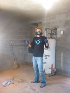 a man standing in front of a refrigerator wearing a gas mask and holding two thumbs up