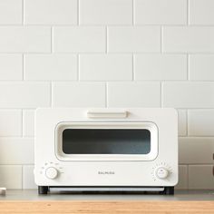 a toaster oven sitting on top of a wooden counter