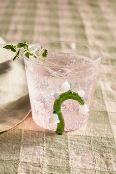 a glass filled with water sitting on top of a table next to a piece of cloth