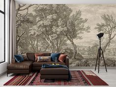 a living room with a couch, rug and wallpaper that has trees on it