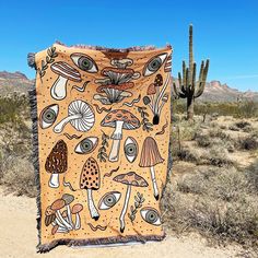 a blanket with an image of mushrooms on it is in the middle of a desert