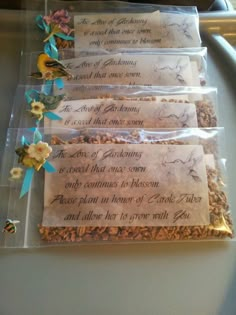 four packages of granola are lined up on a table with paper flowers and ribbons