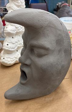 a clay sculpture of a man's face with his mouth open