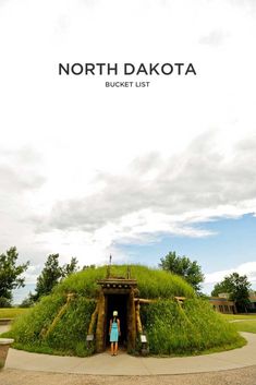 a woman standing in front of a green mound with grass growing on it and the words north dakota bucket list