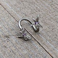 a pair of silver nose rings sitting on top of a cement floor next to a wall