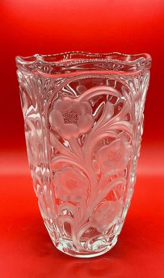 a glass vase sitting on top of a red table