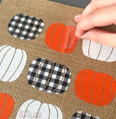 someone is cutting out fabric to make pumpkins on burlocked canvases