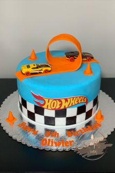 a birthday cake with a hot wheels theme on it's side and an orange handle