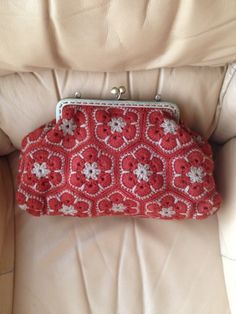 a red purse sitting on top of a white chair