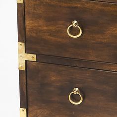 a wooden dresser with two drawers and brass hardware on the bottom, against a white background