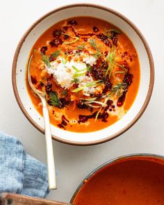 a white bowl filled with soup and garnished with sour cream on the side