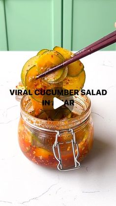 a jar filled with pickles sitting on top of a table