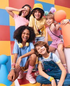 a group of young children posing for a photo in front of colorful wall and floor