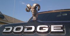 the dodge logo is on the hood of a pickup truck in front of a house