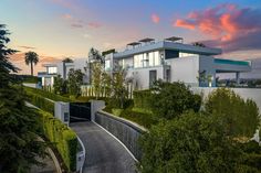 a modern house is shown at dusk with the sun setting on the horizon behind it