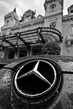 the mercedes logo is on the hood of a car in front of an ornate building