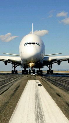 a large jetliner sitting on top of an airport tarmac next to a runway