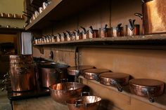 many pots and pans are lined up on the wall