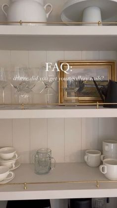 the shelves are filled with white dishes and glassware on top of each other,