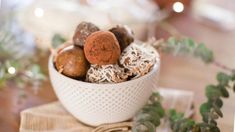 a white bowl filled with different types of chocolates