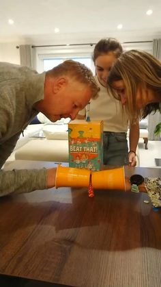 three people standing around a table with boxes on it