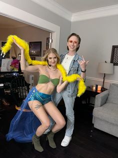 two people dressed up in costumes posing for the camera with one holding a yellow object