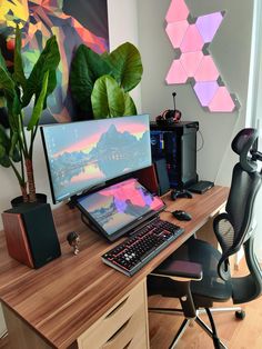 a desk with a computer, keyboard and plant on it in front of a painting