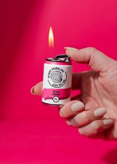 a person holding a can with a candle in it