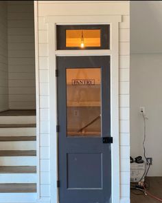 an empty entryway with stairs leading up to the front door and light on above it