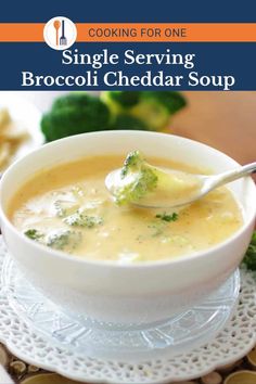 a bowl of broccoli cheddar soup on a plate with a spoon