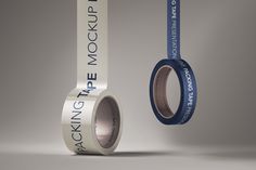 two rolls of packing tape next to each other on a gray background with the words packing up