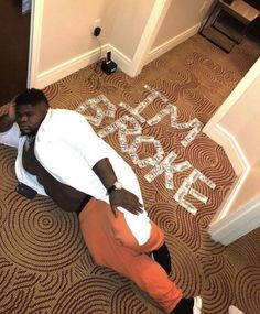 a man sitting on the floor in front of a sign