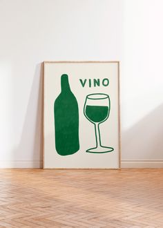 a wine glass and bottle are on the floor in front of a poster that says vino