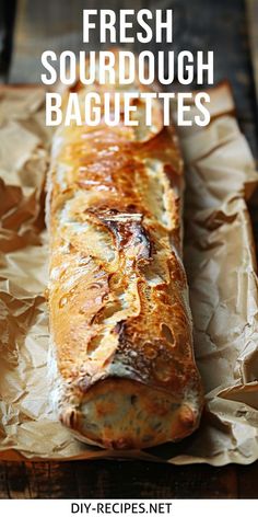 a loaf of fresh sourdough baguettes sitting on top of a piece of wax paper