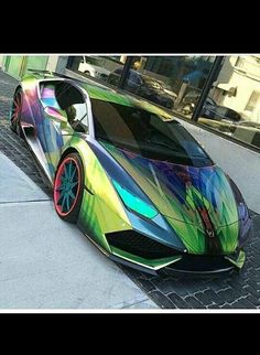 a multicolored sports car parked on the sidewalk