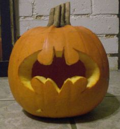 a carved pumpkin with a batman symbol on it